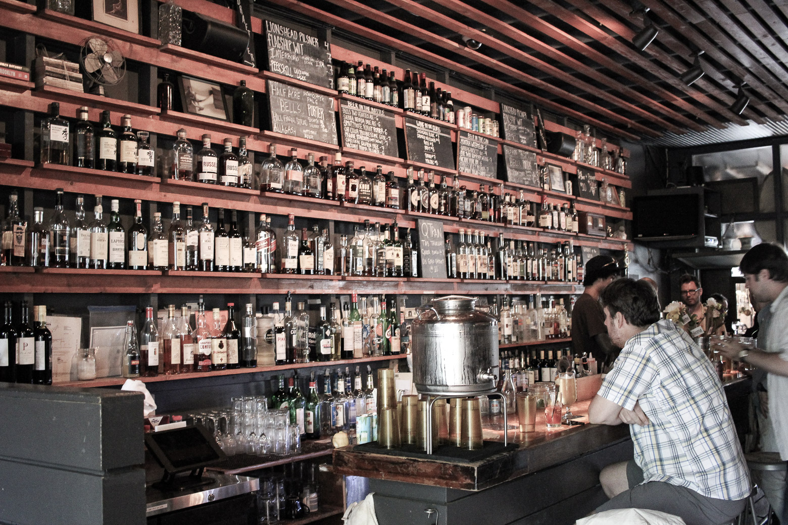 man sitting at a well stocked bar