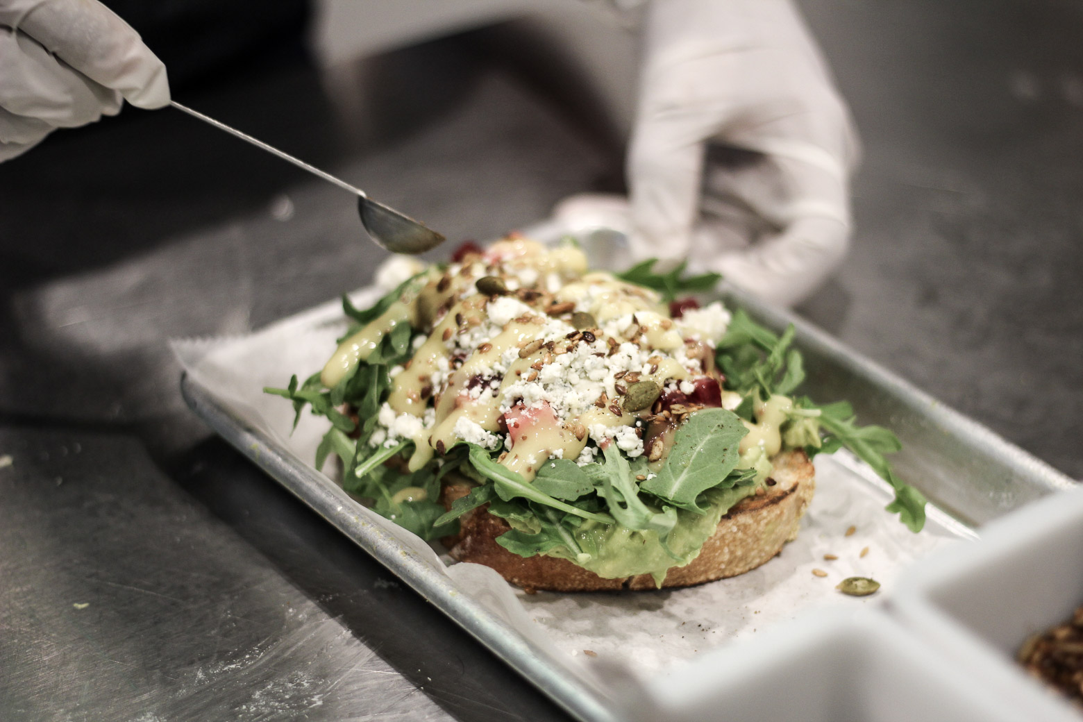 garnishing avocado toast on a counter 